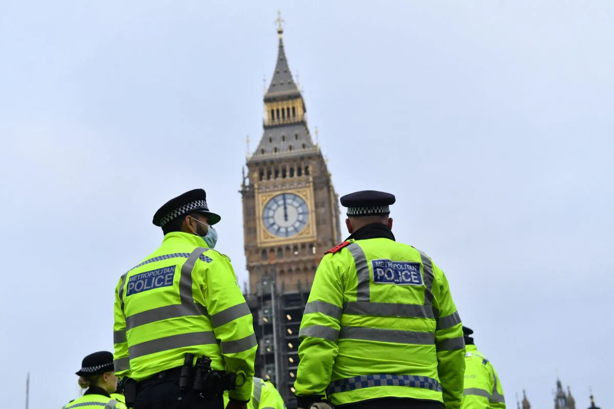 Police officers stand in sight of Big Ben as they monitor a march to protest against the Police, Crime, Sentencing and Courts Bill in London on Jan. 15, 2022. (Justin Tallis/AFP via Getty Images)