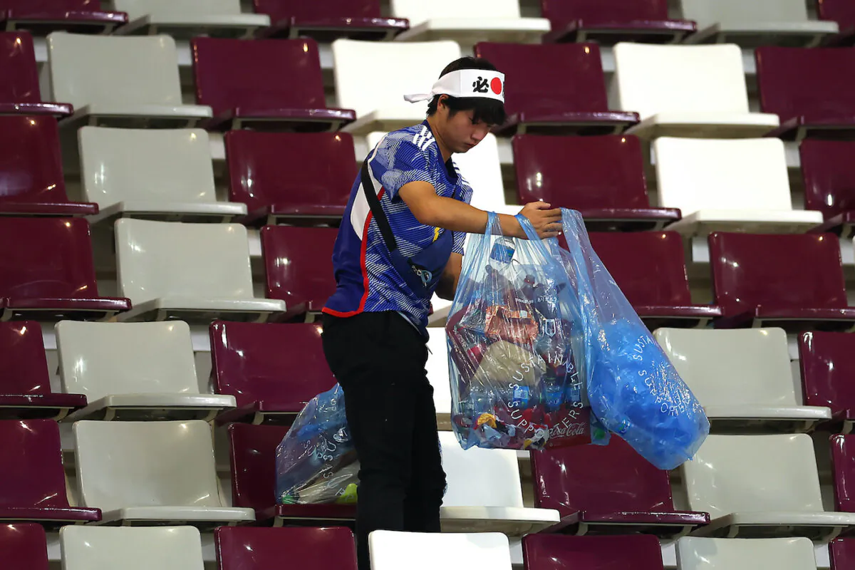 A Japanese fan clears rubbish from the stands during the FIFA World Cup Qatar 2022 Group E match between Germany and Japan at Khalifa International Stadium in Doha, Qatar on Nov. 23, 2022. (Alex Grimm/Getty Images)