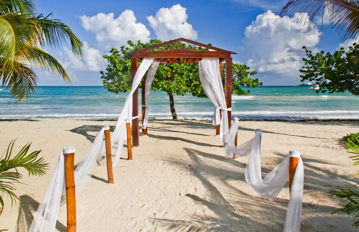 A view of the Caribbean Sea in the distance through a lovely beach side pergola decorated as a wedding venue at the Couples Negril resort in Negril, Jamaica. (Lawrence Weslowski Jr./Dreamstime/TNS)