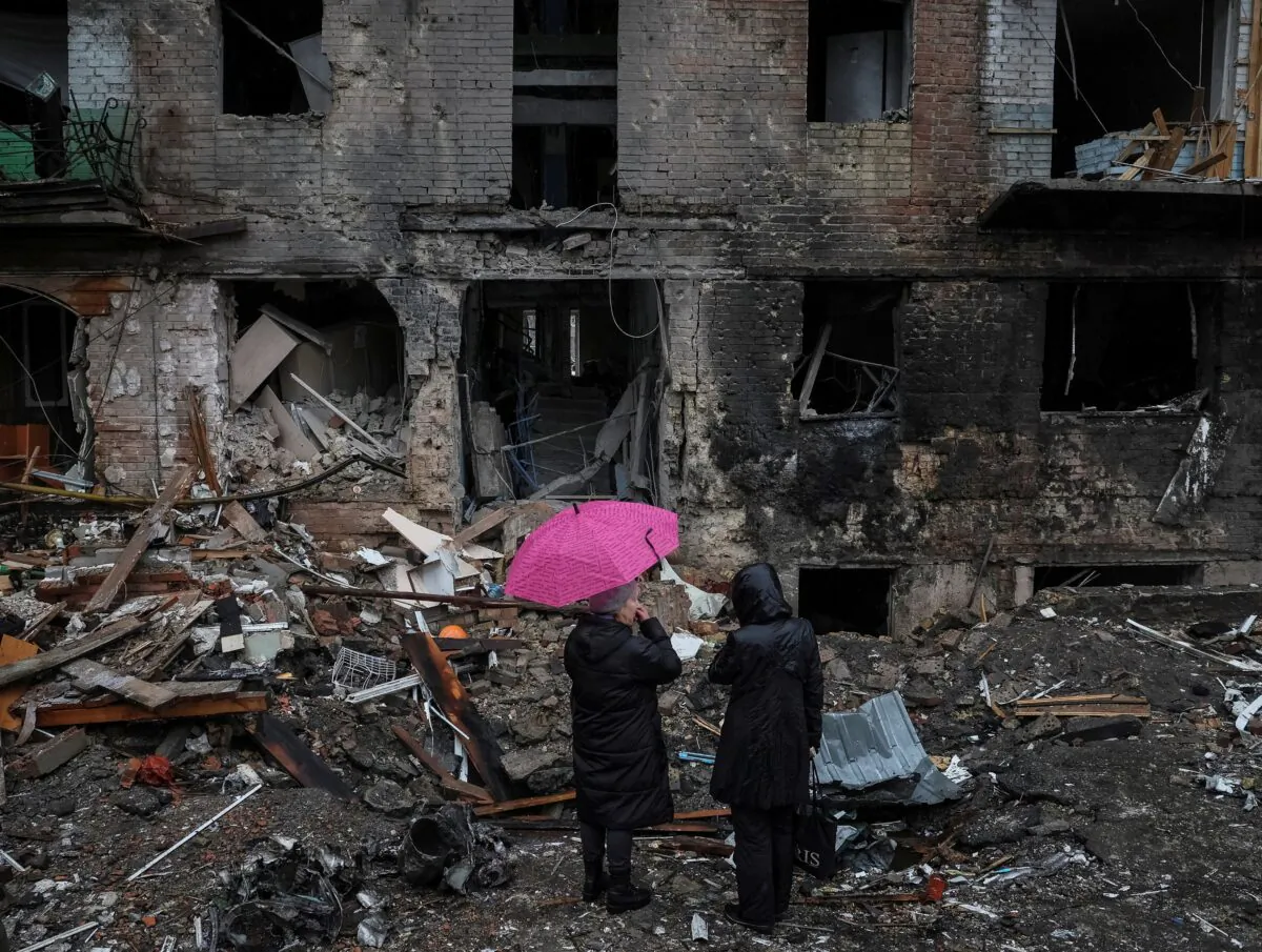 Local residents stand near their building destroyed by a Russian missile attack in the town of Vyshhorod, near Kyiv, Ukraine, on Nov. 24, 2022. (Gleb Garanich/Reuters)