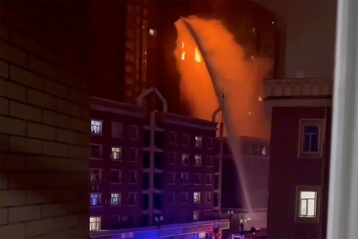 Firefighters spray water on a fire at a residential building in Urumqi in western China's Xinjiang Region on Nov. 24, 2022, in a still from video. (AP Photo)