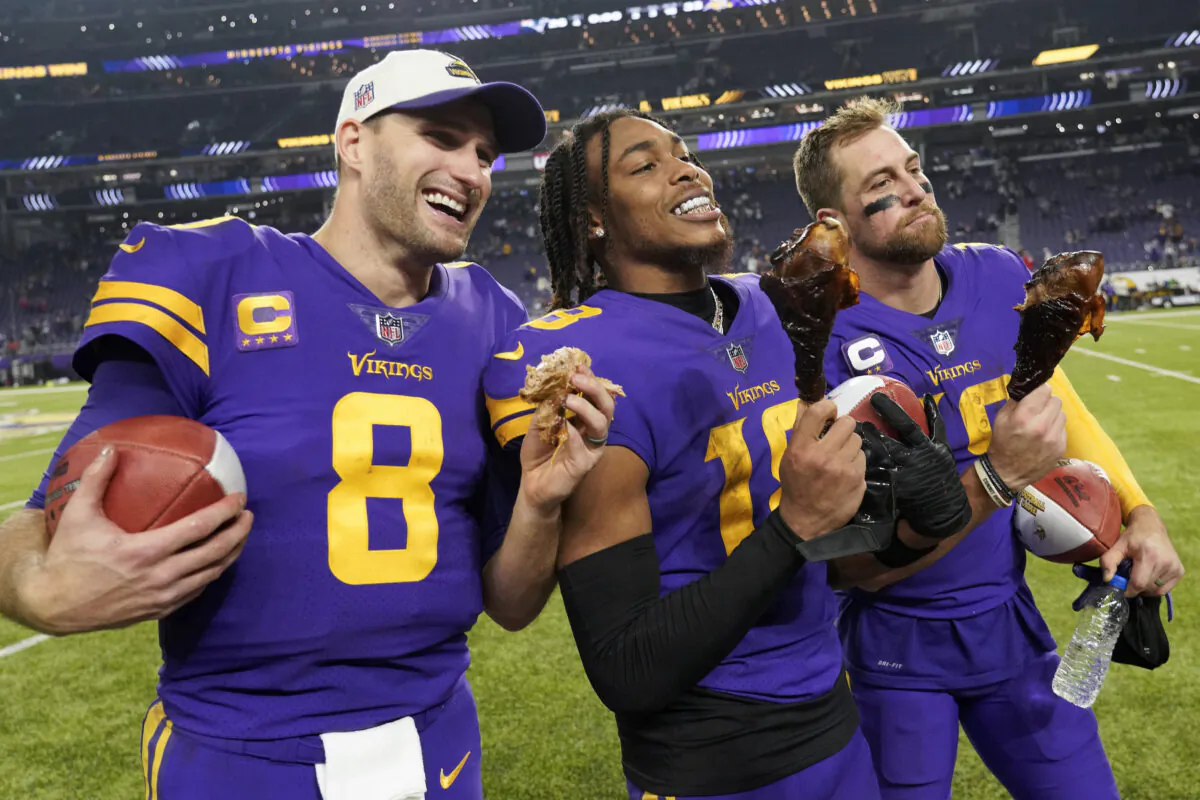 Kirk Cousins (8), Justin Jefferson (18) and Adam Thielen (19) of the Minnesota Vikings eat turkey legs on the field after defeating the New England Patriots at U.S. Bank Stadium in Minneapolis, Minn. on Nov. 24, 2022. (David Berding/Getty Images)