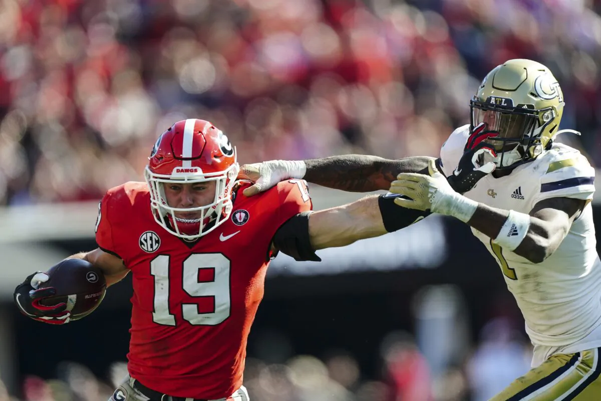 Georgia tight end Brock Bowers (19) fends off Georgia Tech defensive back Zamari Walton (7) as he run after a catch during the first half of an NCAA college football game in Athens, Ga., Nov. 26, 2022. (John Bazemore/AP Photo)