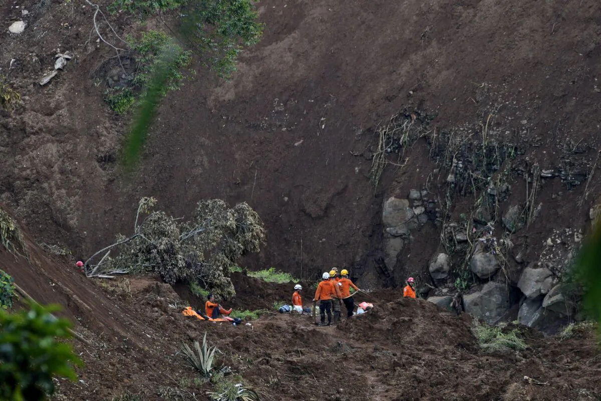 Rescuers search for victims at the site where an earthquake-triggered landslide hit in Cianjur, West Java, Indonesia, on Nov. 25, 2022. (Achmad Ibrahim/AP Photo)