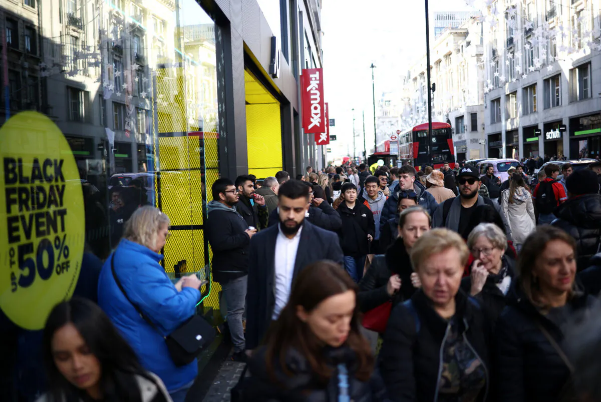 People walk past Black Friday signage in shop windows during Black Friday on Oxford Street in London on Nov. 25, 2022. (Henry Nicholls/Reuters)