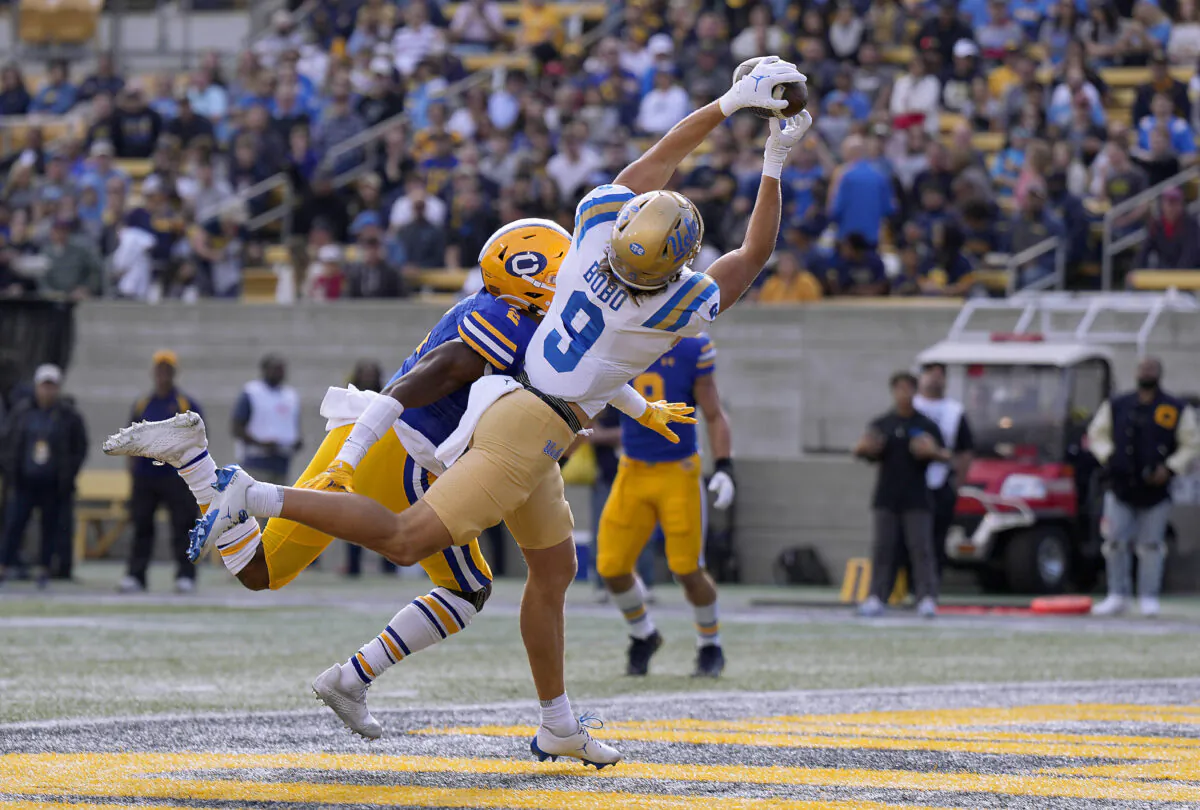 Jake Bobo (9) of the UCLA Bruins catches a 5 yard touchdown pass over Craig Woodson (2) of the California Golden Bears during the first quarter of an NCAA football game at California Memorial Stadium in Berkeley, Calif., on Nov. 25, 2022. (Thearon W. Henderson/Getty Images)