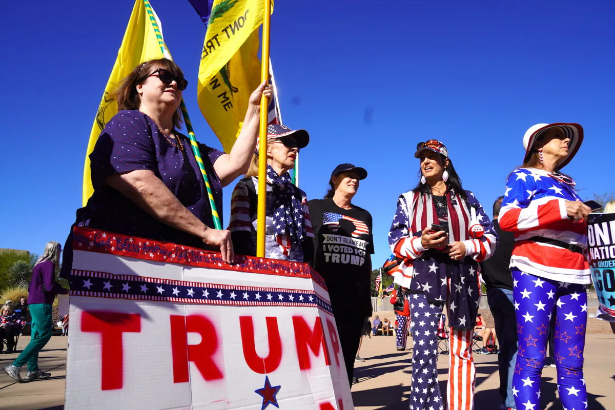 Protesters at a sit-in demonstration to call for a new midterm election in Arizona's Maricopa County hold banners and flags to show their support for the effort on Nov. 25, 2022. (Allan Stein/The Epoch Times)