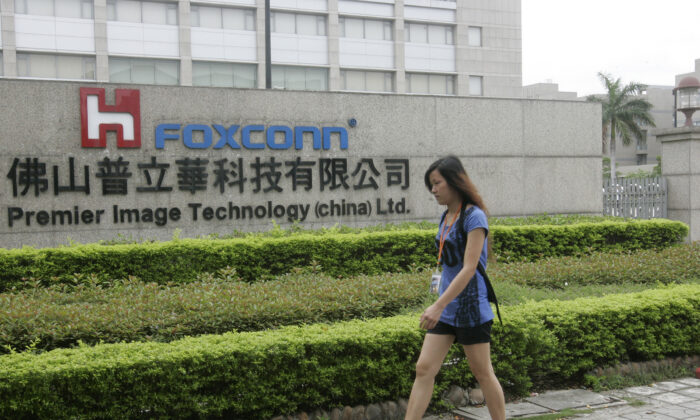 A Chinese worker walks past a Foxconn factory in an industrial district of Foshan City, southern China's Guangdong province on June 17, 2010. (STR/AFP via Getty Images)