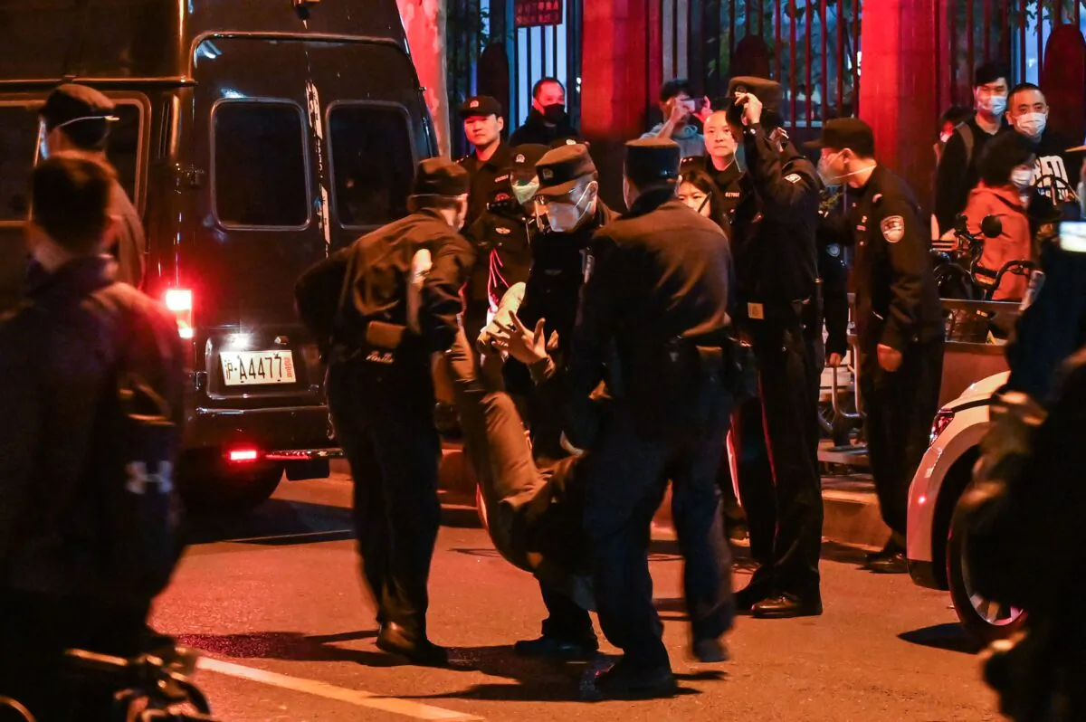 A man is arrested while protesters gathered on a street in Shanghai on Nov. 27, 2022. Protests against China's 'zero-COVID' policy took place the night before following a deadly fire in Urumqi, the capital of the Xinjiang region. (Hector Retamal/AFP via Getty Images)