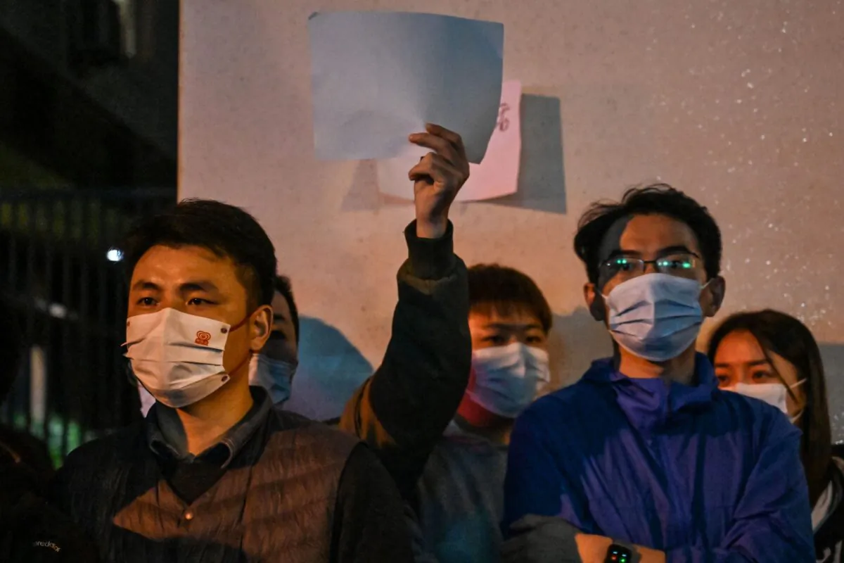 People showing blank papers as a way to protest gather on a street in Shanghai, on Nov. 27, 2022, where protests against China's zero-COVID policy took place the night before following a deadly fire in Urumqi, the capital of the Xinjiang region. (Hector Retamal/AFP via Getty Images)