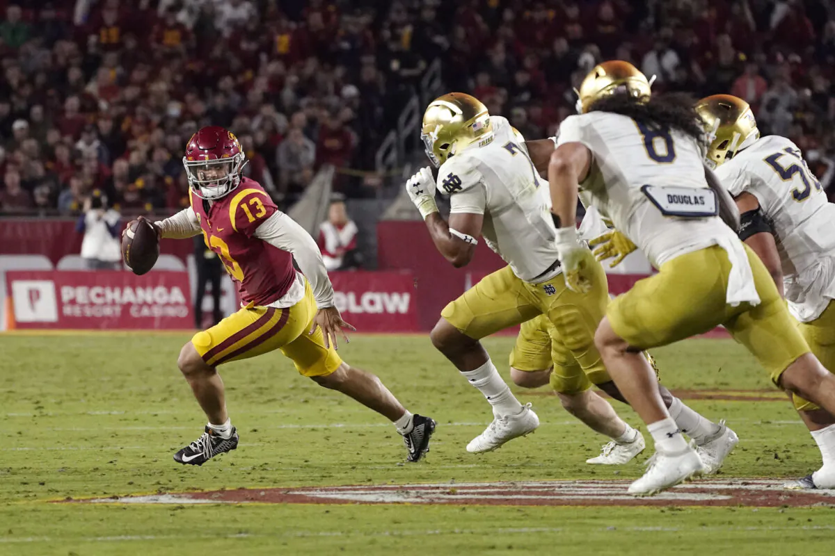 Southern California quarterback Caleb Williams, left, is chase by members of Notre Dame during the first half of an NCAA college football game, in Los Angeles Nov. 26, 2022. (Mark J. Terrill/AP Photo)