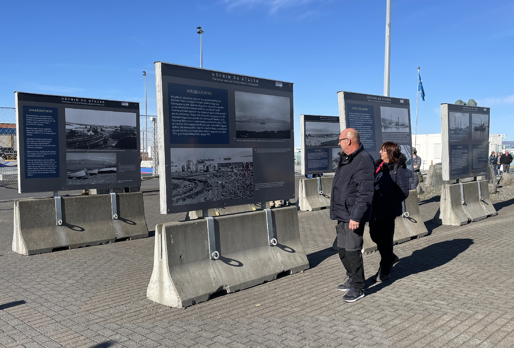 Visitors examine historical photos and information at a public display along the Old Harbor in Reykjavik, Iceland.