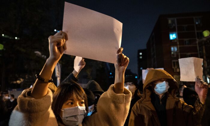 Protesters hold up pieces of paper against censorship and China's strict 'zero-COVID' measures in Beijing on Nov. 27, 2022. (Kevin Frayer/Getty Images)