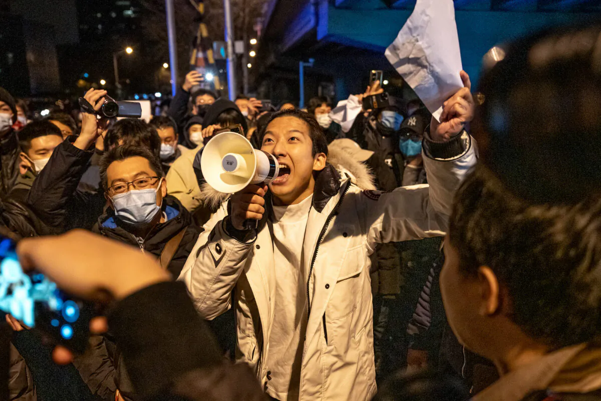 A demonstrator holds a blank sign and chants slogans during a protest in Beijing on Nov. 28, 2022. (Bloomberg via Getty Images)