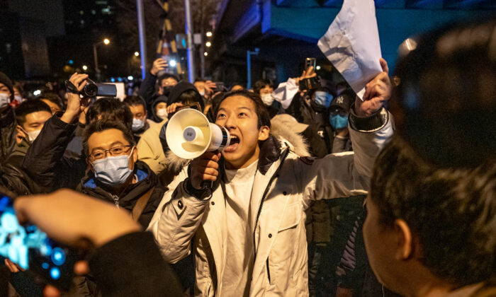 A demonstrator holds a blank sign and chants slogans during a protest in Beijing on Nov. 28, 2022. (Bloomberg via Getty Images)