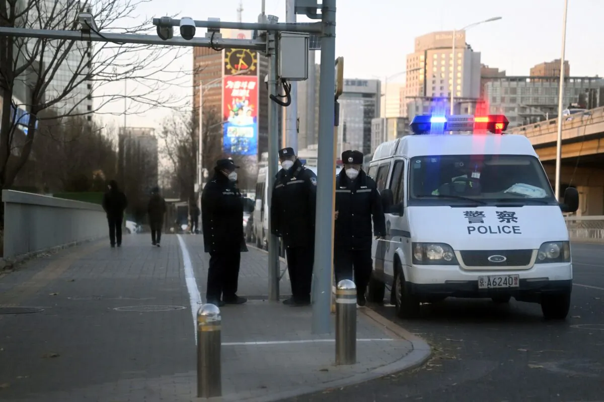 Police keep watch on a road by the Liangma River, where recent protests took place for victims of a deadly fire as well as against China's harsh Covid-19 restrictions, in Beijing on Nov. 29, 2022. (Noel Celis/AFP via Getty Images)