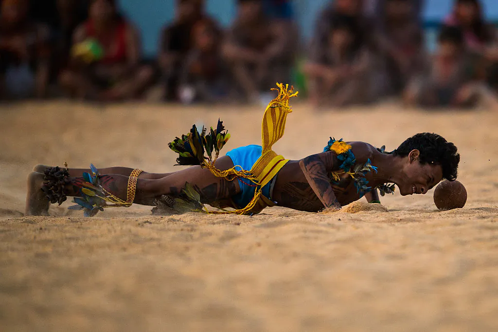 An indigenous man from the Paresi tribe tries to head the ball during the Jikunahati competition, a form of soccer played with one's head during at the World Indigenous Games in Palmas, Brazil, on Oct. 26, 2015.  (Photo by Buda Mendes/Getty Images)