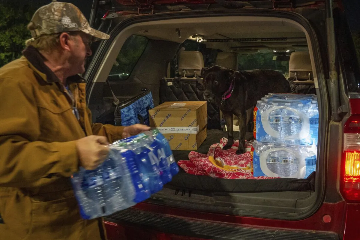 John Beezley loads several cases of water after learning that a boil water notice was issued for the entire city of Houston at Walmart on S. Post Oak Road in Houston on Nov. 27, 2022. (Mark Mulligan/Houston Chronicle via AP)