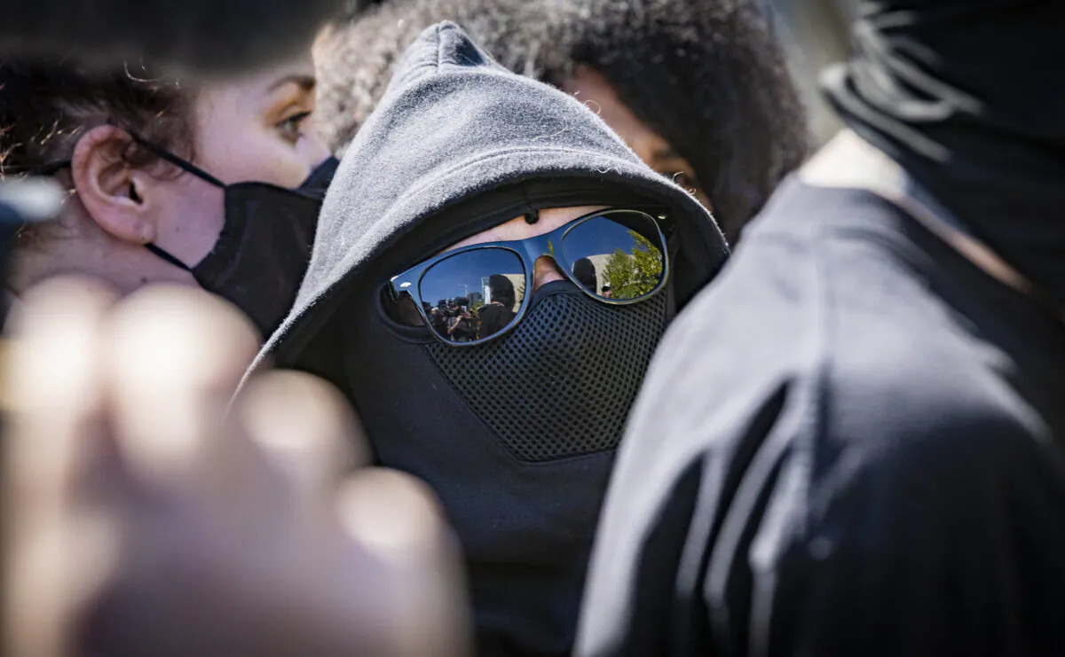 Men and women dressed in black attended a protest in Los Angeles, Calif., on Oct. 20, 2021. (John Fredricks/The Epoch Times)