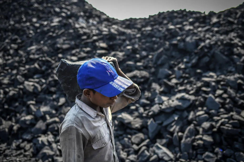 Workers carry coal at a coal yard near a mine in Sonbhadra, Uttar Pradesh India, on Nov. 23, 2021. (Ritesh Shukla/Getty Images)