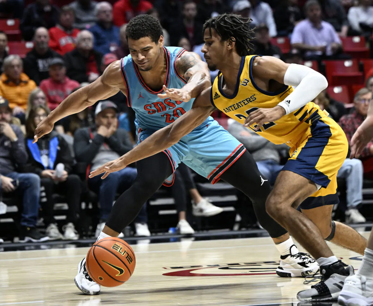 San Diego State guard Matt Bradley (20) and UC Irvine guard DJ Davis (22) vie for the ball during the first half of an NCAA college basketball game in San Diego, on Nov. 29, 2022. (Denis Poroy/AP Photo)