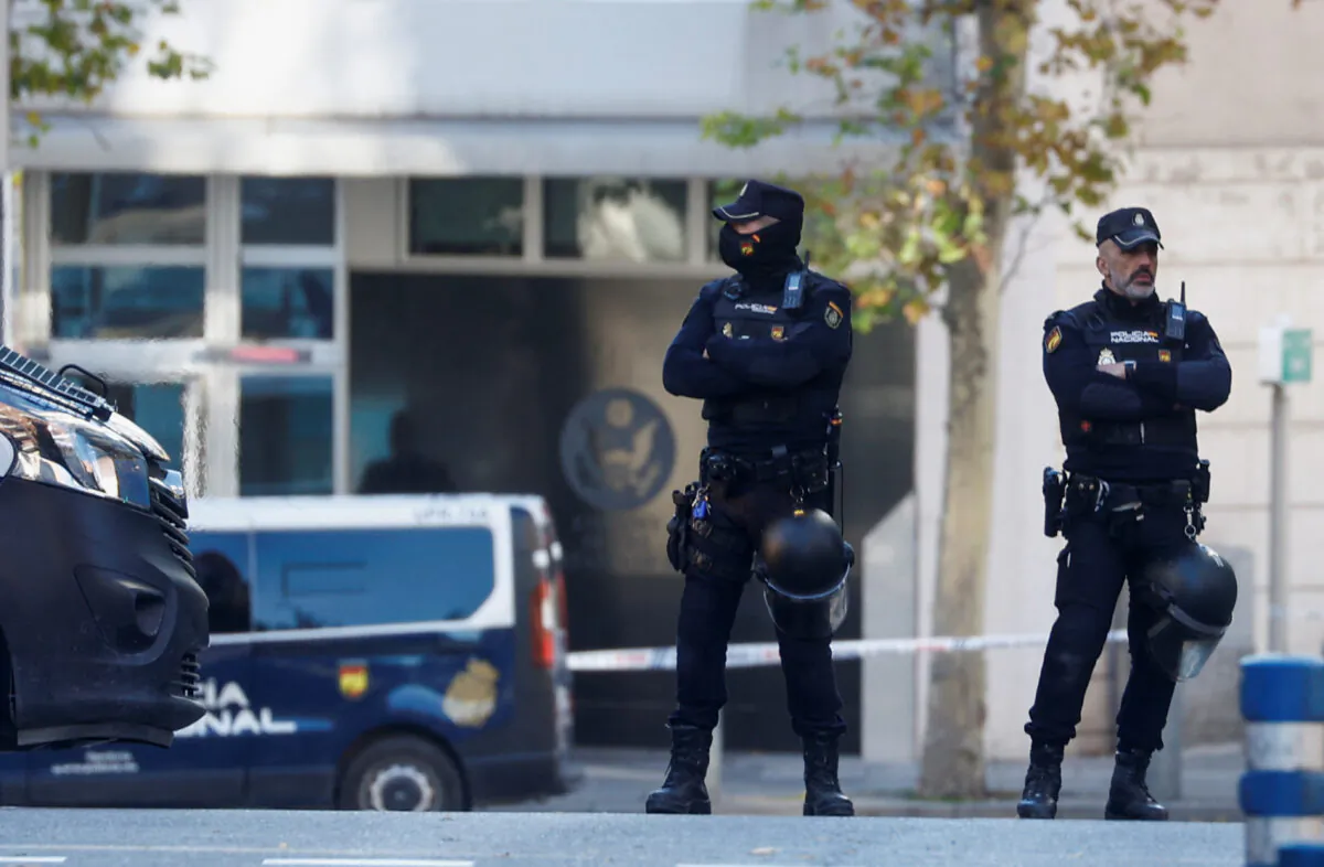 Police officers stand outside the U.S. Embassy in Madrid after a suspected explosive device hidden in an envelope was mailed to the embassy, in Madrid, Spain, on Dec. 1, 2022. (Juan Medina/Reuters)