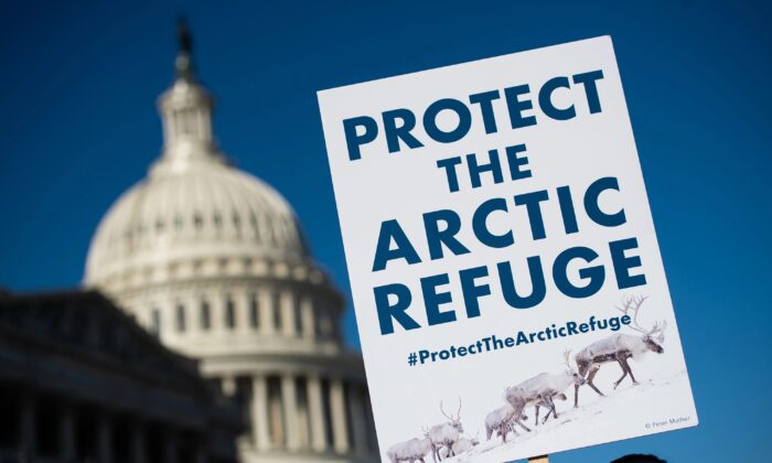 A demonstrator holds a sign against drilling in the Arctic Refuge on the 58th anniversary of the Arctic National Wildlife Refuge, during a press conference outside the U.S. Capitol in Washington, D.C., on Dec. 11, 2018. (Saul Loeb/AFP/Getty Images)