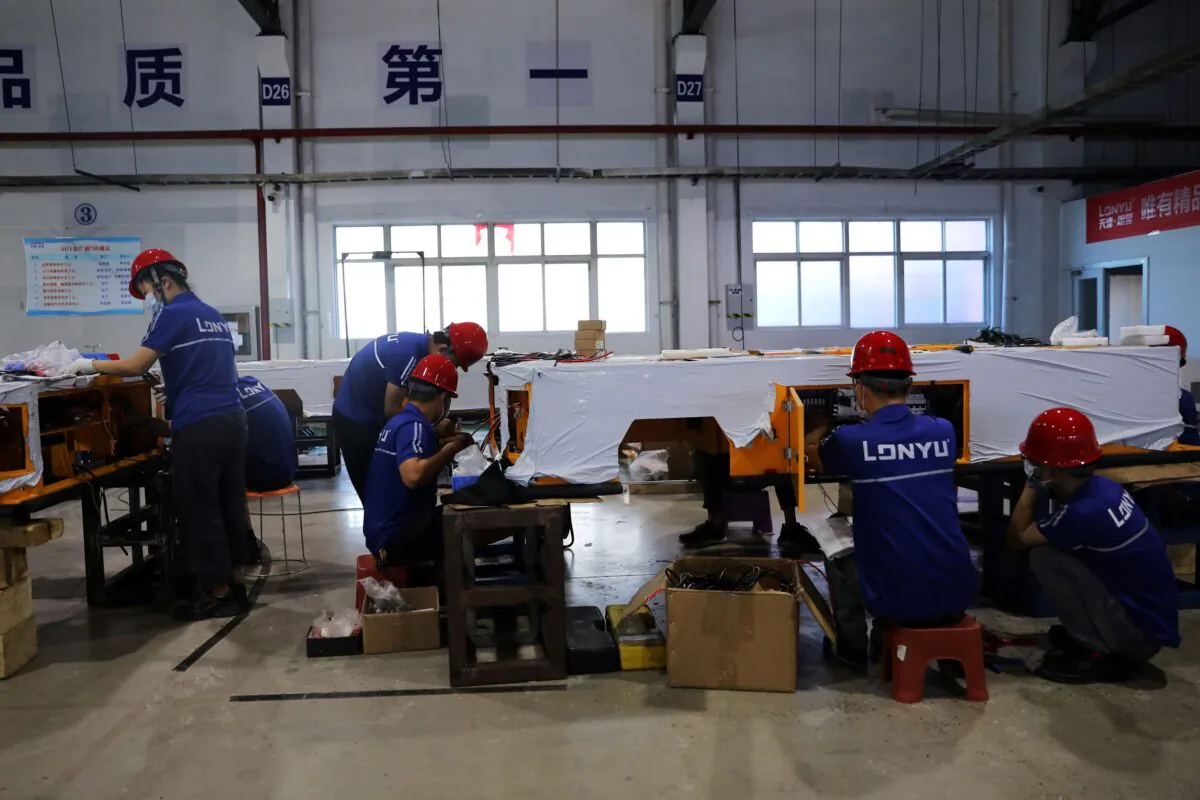 Employees work on assembling automated guided vehicles (AGV) at a Lonyu Robot Co. factory in Tianjin, China, on Sept. 7, 2021. (Tingshu Wang/Reuters)