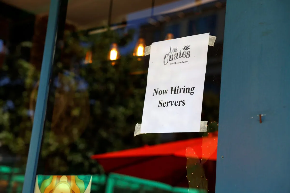 A "Now Hiring Servers" sign is displayed in front of "Los Cuates" Mexican Restaurant in Adams Morgan neighborhood in Washington on Oct. 7, 2022. (Anna Moneymaker/Getty Images)
