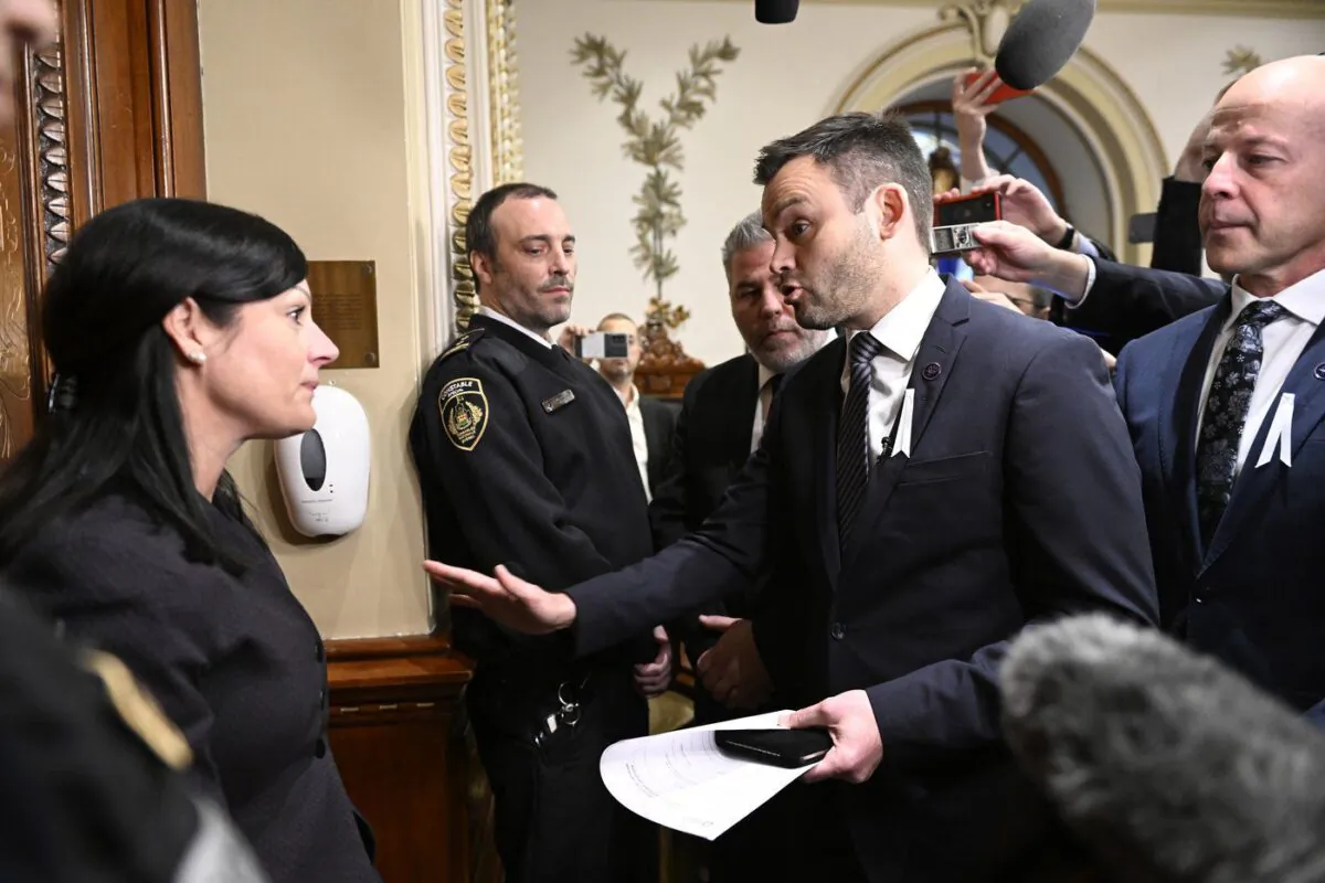 Parti Québécois Leader Paul St-Pierre Plamondon, centre, speaks to the sergeant-at-arms Véronique Michel, who prevented the three PQ elected members to enter the Blue Room at the legislature in Quebec City, Dec. 1, 2022. (The Canadian Press/Jacques Boissinot)