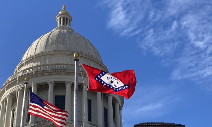 The Arkansas State Flag and U.S. flag fly in front of the State Capitol in Little Rock, Ark., on Dec. 1, 2022. (Janice Hisle/The Epoch Times)