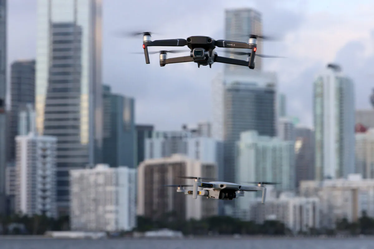 A DJI Mavic 2 Pro and DJI Mavic Mini made by the Chinese drone maker fly near each other in Miami, Florida, on Dec. 15, 2021. (Joe Raedle/Getty Images)