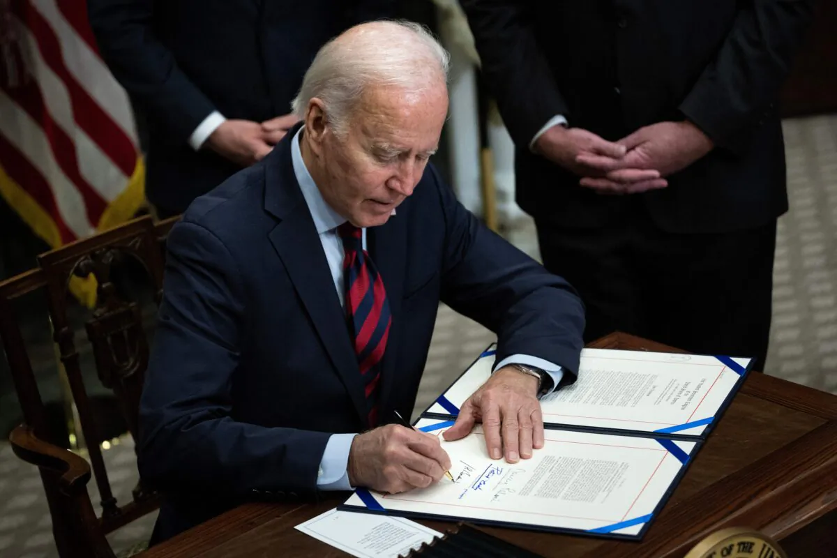 President Joe Biden signs a resolution to avert a nationwide rail shutdown, in Washington on Dec. 2, 2022. (Brendan Smialowski/AFP via Getty Images)