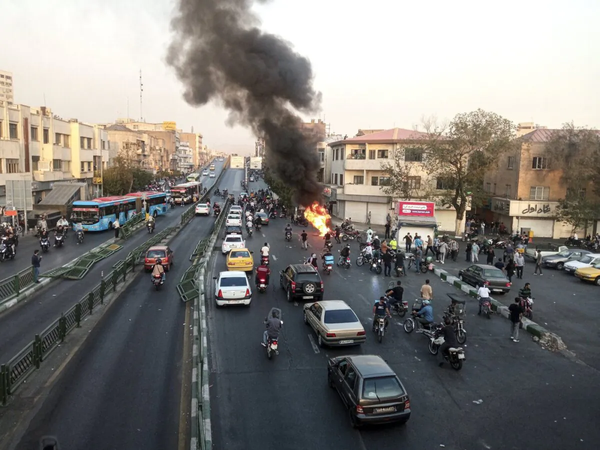 A motorcycle of Basij, Iranian paramilitary militia, is set on fire during a protest after a 22-year-old woman Mahsa Amini's death when she was detained by the morality police, in Tehran, Oct. 10, 2022 (The Canadian Press/AP-Middle East Images)