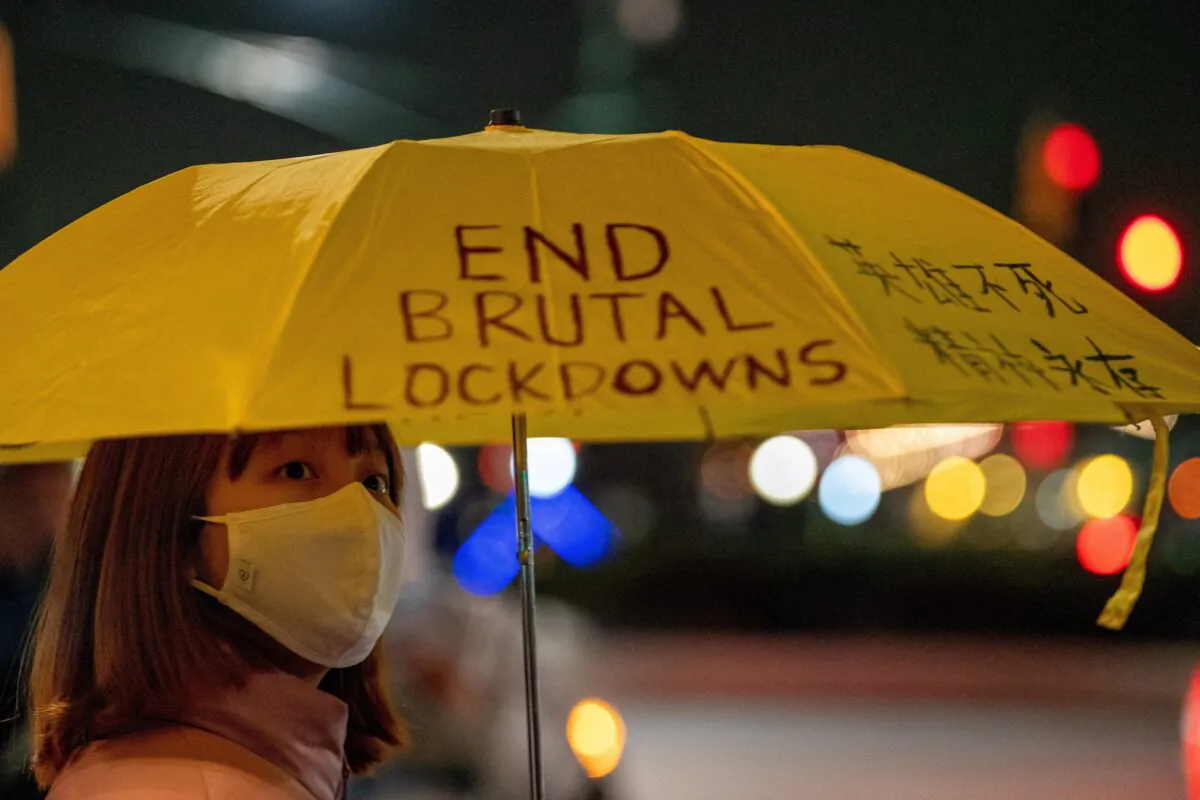 A woman holding an umbrella with a slogan on it takes part in an anti-CCP protest, amid China's stringent zero-COVID policy, near the Chinese consulate in New York on Nov. 29, 2022. (David 'Dee' Delgado/Reuters)