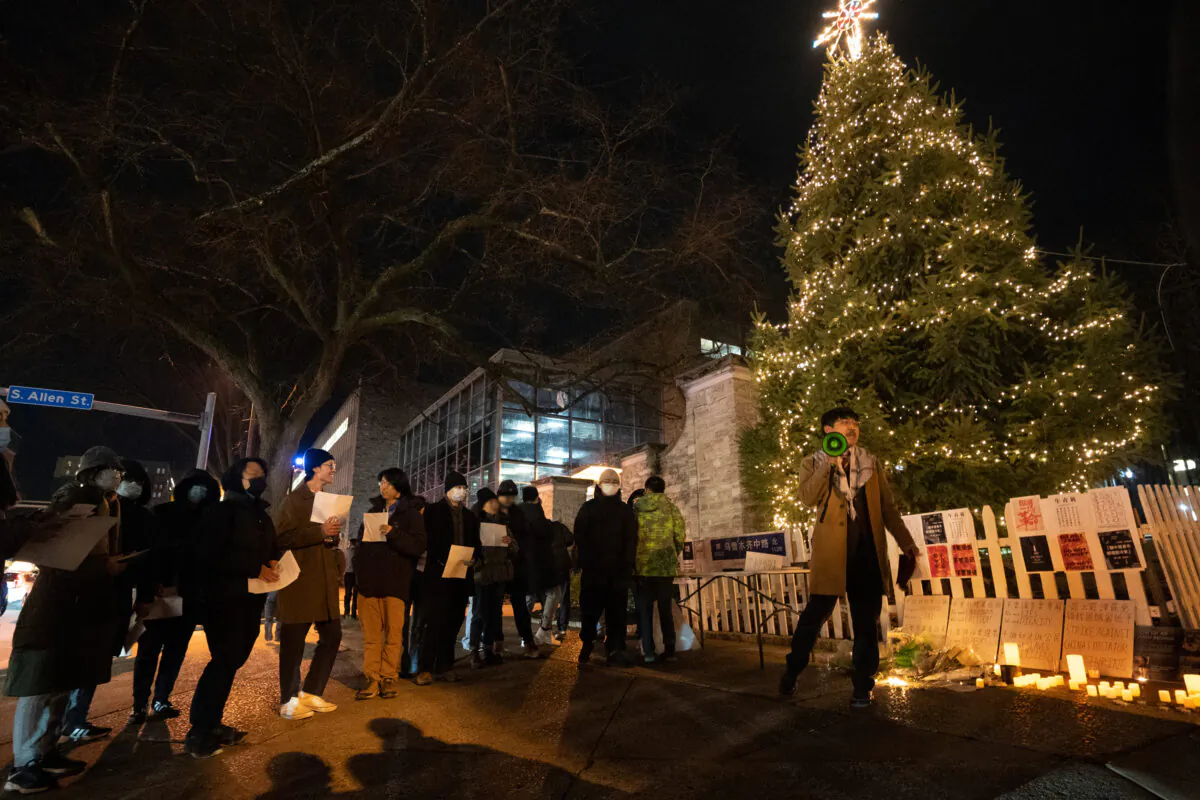 Around 50 students gathered in front of the Allen St. Gate on Penn State's main campus, Pa., holding a candlelight vigil in memory of victims of the Urumqi fire, on Dec. 2, 2022. (Serena Shi/The Epoch Times)