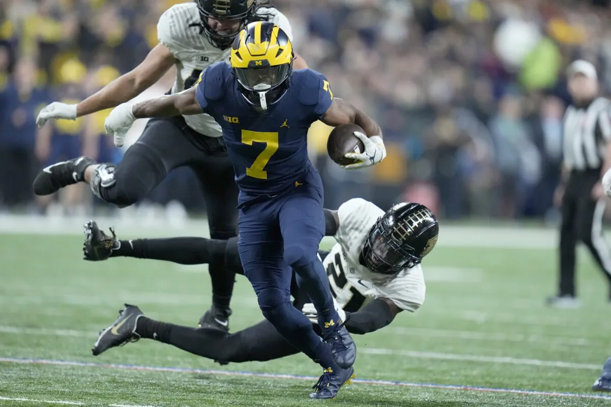 Michigan running back Donovan Edwards (7) runs with the ball as Purdue safety Sanoussi Kane (21) defends during the second half of the Big Ten championship NCAA college football game in Indianapolis, on Dec. 3, 2022. (Michael Conroy/AP Photo)