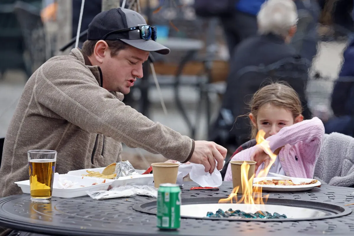 Eden Maracco, 8, has lunch with her dad Jeffery while power is out at her home, at Reds Food Truck Corner in Southern Pines, N.C., on Dec. 5, 2022. (Karl B DeBlaker/AP Photo)