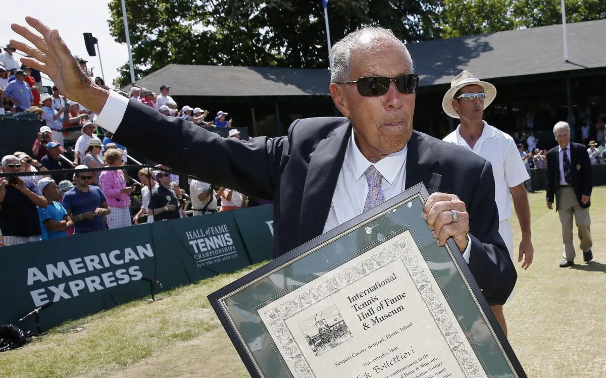 Nick Bollettieri holds his plaque as he waves to the crowd after his induction into the International Tennis Hall of Fame in Newport, R.I., on July 12, 2014. (Michael Dwyer/AP Photo)