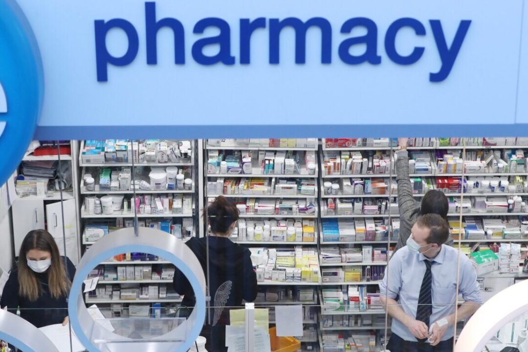Pharmacists working in the Life Pharmacy on March 19, 2020. (Niall Carson/PA Media)