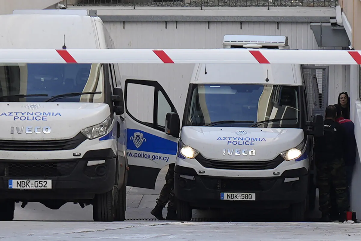 Officers stand by a police van as they leave the grounds of the courthouse complex after the trial of David Hunter in the southwest coastal city of Paphos, Cyprus, on Dec. 5, 2022. (Petros Karadjias/AP Photo)