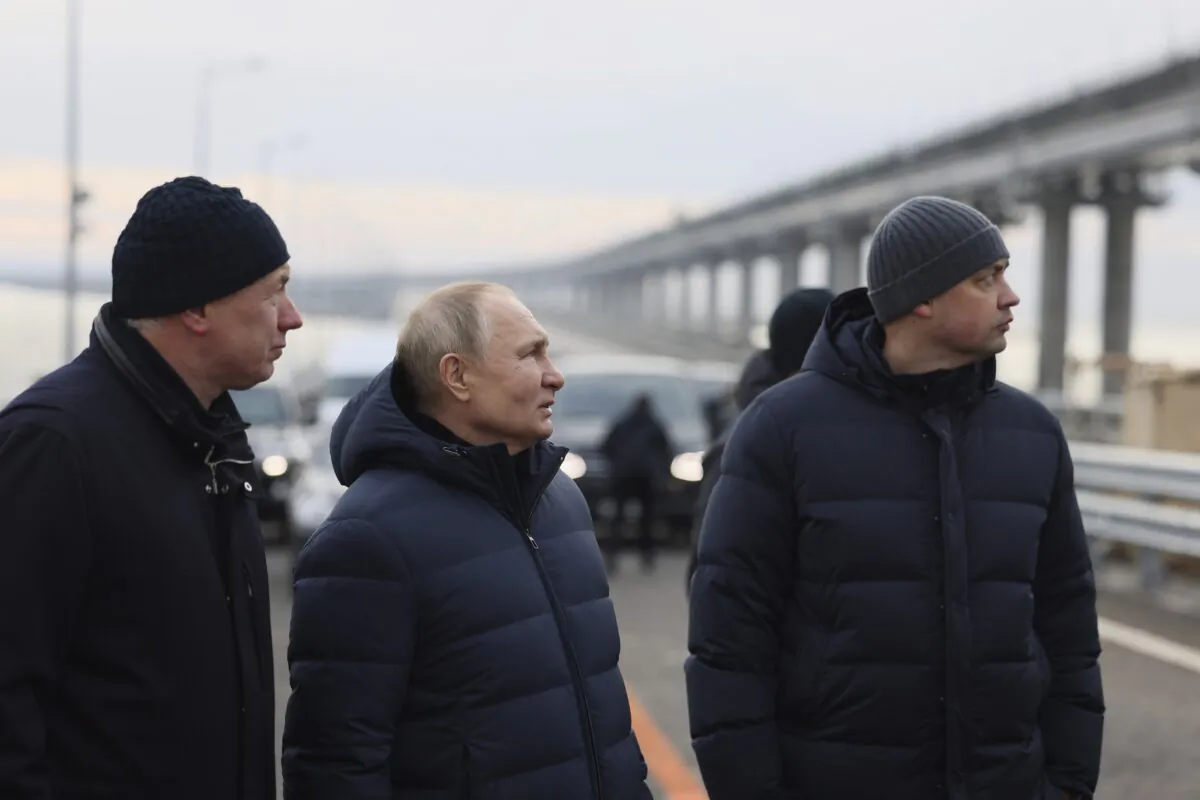Russian President Vladimir Putin (C) and Deputy Prime Minister Marat Khusnullin (L) visit the Crimean Bridge connecting Russian mainland and Crimean peninsula over the Kerch Strait, which was damaged by a truck bomb attack in October, after restoration works, not far from Kerch, Crimea, on Dec. 5, 2022. (Mikhail Metzel, Sputnik, Kremlin Pool Photo via AP)
