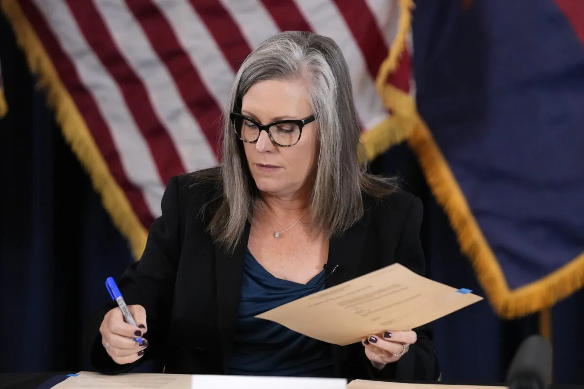 Katie Hobbs, the Democrat governor-elect and current secretary of state, signs the official certification for the Arizona general election canvass during a ceremony at the Arizona Capitol in Phoenix on Dec. 5, 2022. (Ross D. Franklin/Pool/AP Photo)