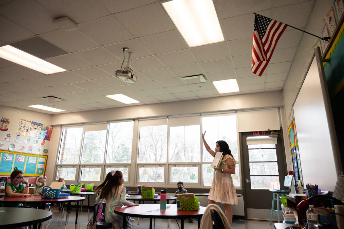 A teacher gestures to her class of mask wearing students during a socially distanced classroom session at Medora Elementary School in Louisville, Ky. on March 17, 2021. (Jon Cherry/Getty Images)