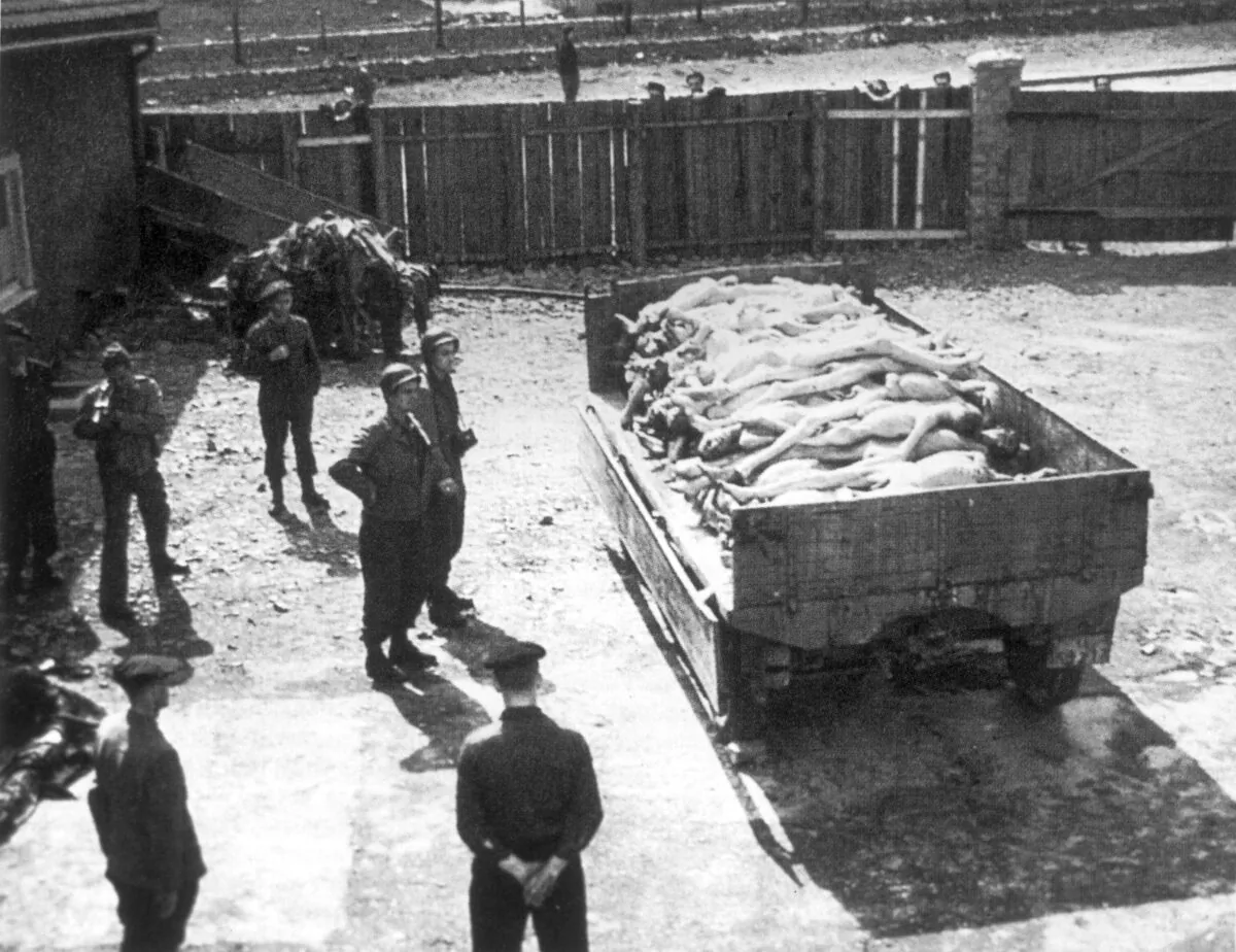 April 1945: Full-length view of Allied soldiers standing beside a truck containing naked corpses from the death camp at Buchenwald, Germany. (Hulton Archive/Getty Images)