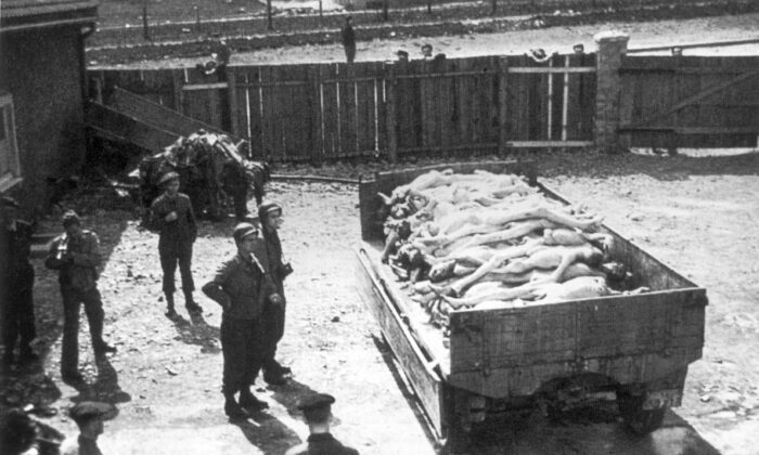April 1945: Full-length view of Allied soldiers standing beside a truck containing naked corpses from the death camp at Buchenwald, Germany. (Hulton Archive/Getty Images)