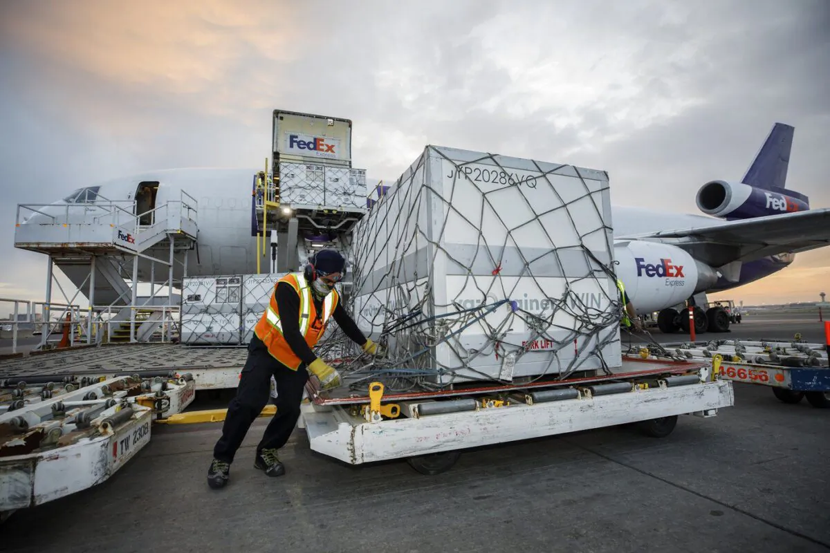 Workers unload a shipment of the Moderna COVID‑19 vaccine at the FedEx hub at Pearson International Airport in Toronto on May 20, 2021. (The Canadian Press/Cole Burston)