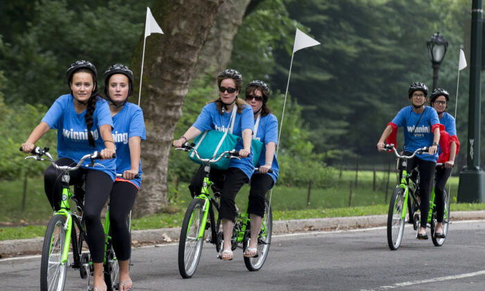 2015 年 7 月 15 日，一对双胞胎在纽约中央公园骑双人自行车。（Brendan McDermid/路透社）