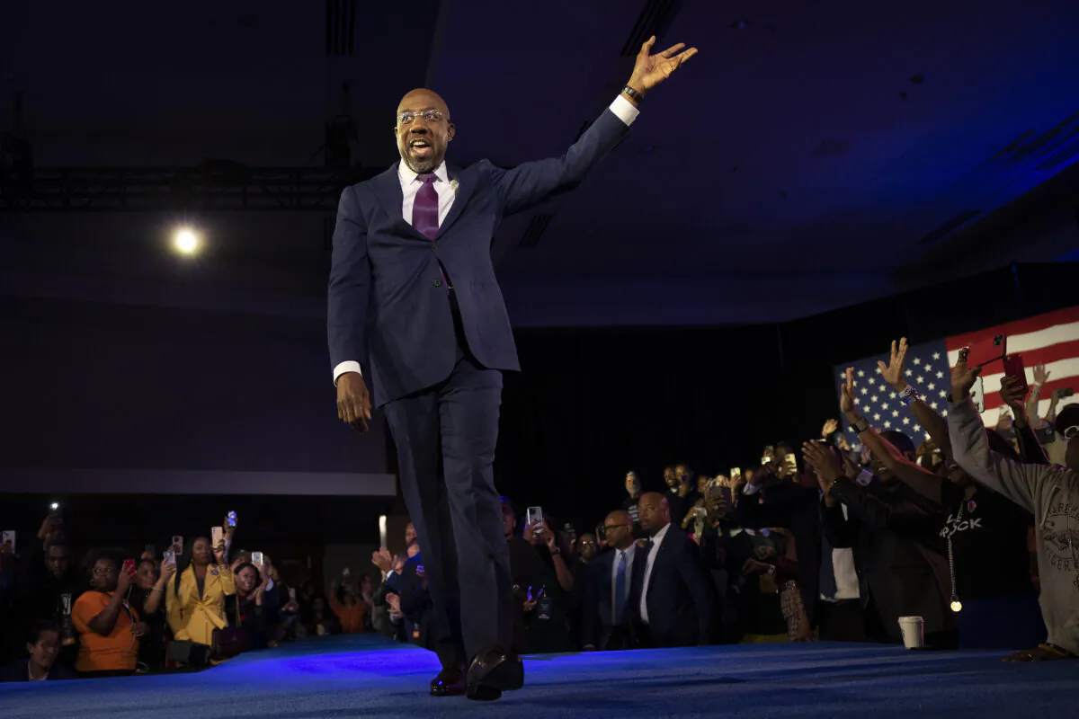 Georgia Democratic Senate candidate U.S. Sen. Raphael Warnock (D-Ga.) waves to supporters as he walks on stage to speak during an election night watch party at the Marriott Marquis in Atlanta on Dec. 6, 2022. (Win McNamee/Getty Images)