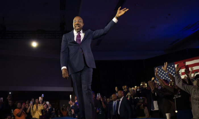 Georgia Democratic Senate candidate U.S. Sen. Raphael Warnock (D-Ga.) waves to supporters as he walks on stage to speak during an election night watch party at the Marriott Marquis in Atlanta on Dec. 6, 2022. (Win McNamee/Getty Images)